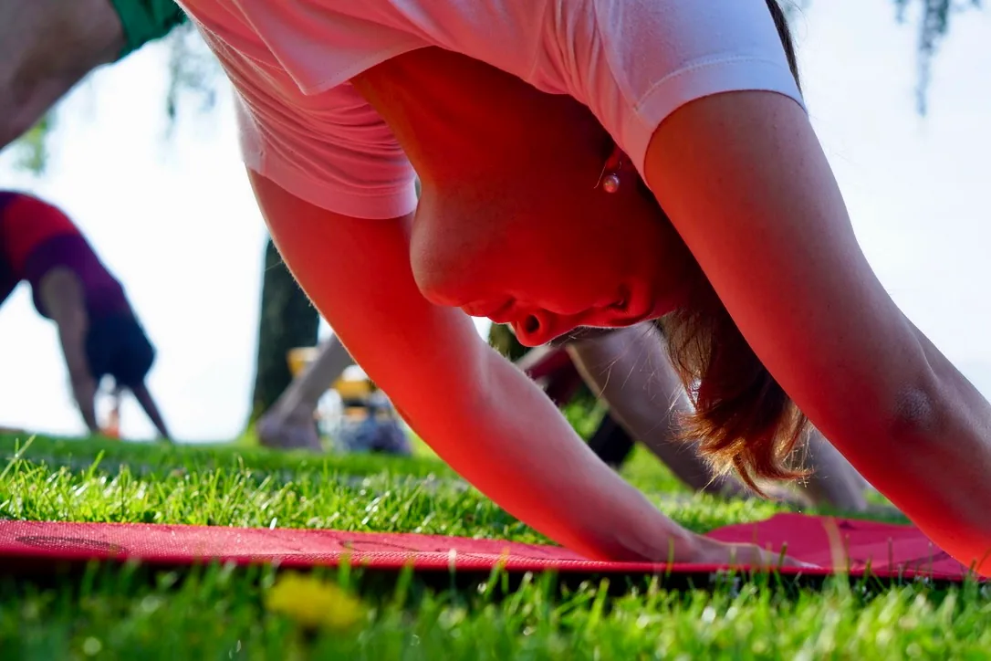 A participant practising downward-facing dog during an outdoor UNITY class