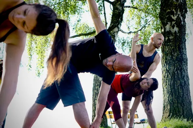 A teacher guiding a lakeside group practice