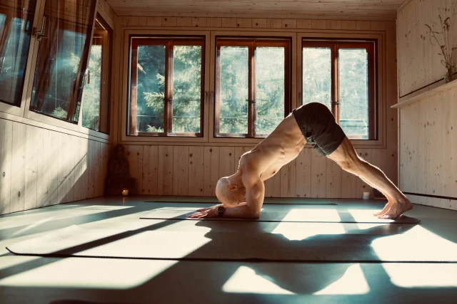 Felix tient la posture du dauphin, les avant-bras et les pieds au sol, le bassin soulevé en V inversé.