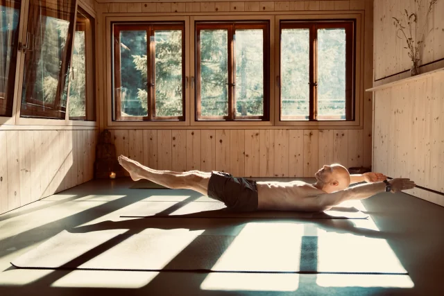 Felix tient le bateau bas, les jambes tendues soulevées, la tête et les épaules levées et les bras étendus au-dessus de la tête.
