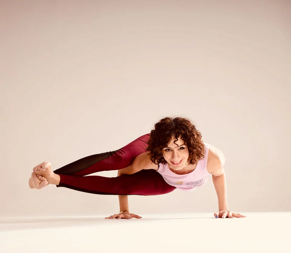 Nour smiling in a balancing yoga pose
